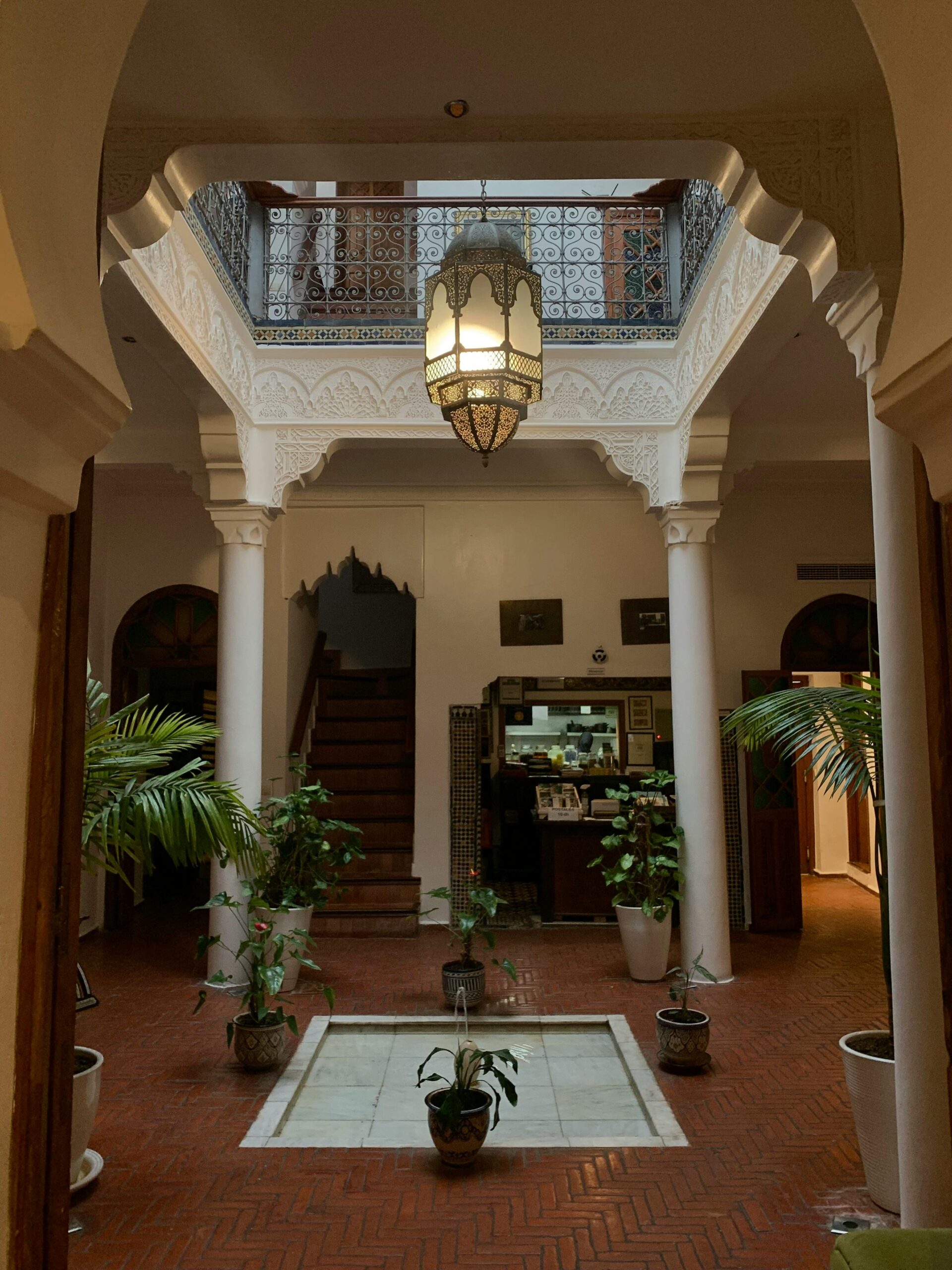 Stunning interior of a Moroccan riad with traditional architecture and lush greenery.
